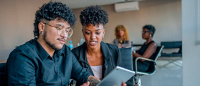 A man and woman discussing eachother using laptop.