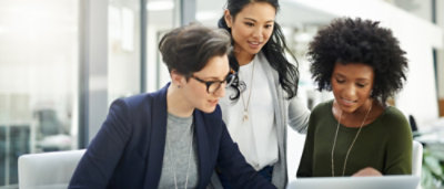 A group of women looking at a laptop.