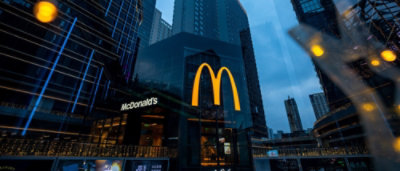 A McDonald's restaurant sign on a building in a city.