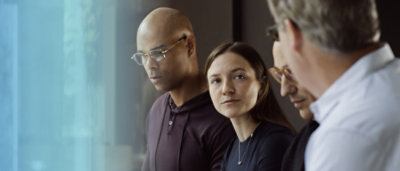 A man and woman looking out a window.