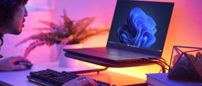 A laptop with a blue screen on a desk.