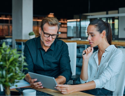 A women and a man looking into tab screen.