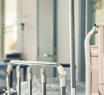 A hospital or clinical setting, hospital bed with metal railings.
