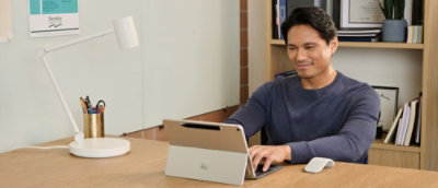 A person sitting at a desk using a laptop.