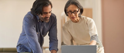 Two people reviewing content together on a laptop