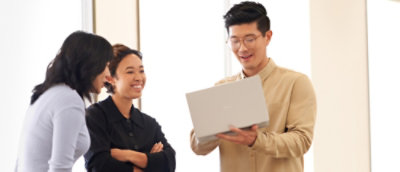 Three people looking at the laptop and discussing