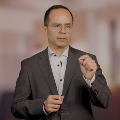 Person presenting information with hand gestures in a studio environment.