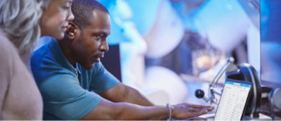 A men and women looking at a computer.