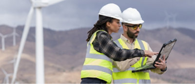 A man and woman wearing safety vests and helmets.