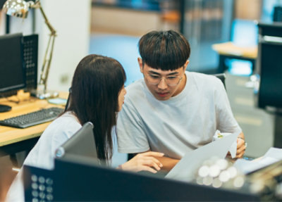 A man and woman looking at a piece of paper.