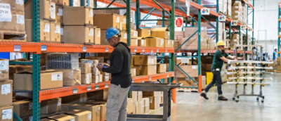 Workers inventorying and organizing items in a warehouse.