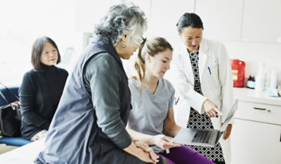 A group of people looking at a computer screen.