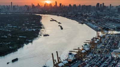 A river with boats and a city skyline in the background.