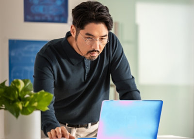 Person working on a laptop at a desk in a modern office setting