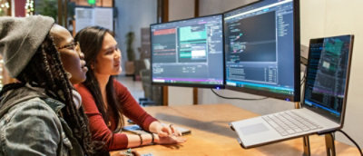En person, der sidder ved et skrivebord og kigger på en computerskærm