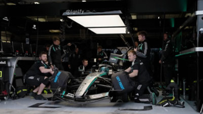 FI team servicing a Formula racing car inside a pit garage during maintenance