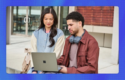 A man and woman looking at a computer 