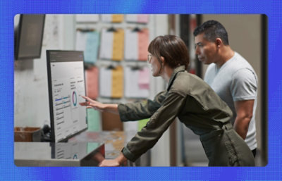 A man and woman looking at a monitor in office setup