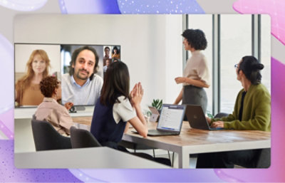 A group of people in a conference room with a Teams Meeting onscreen on a wall mounted television