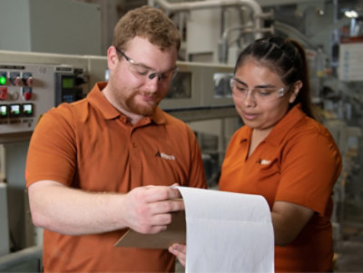 A man and woman looking at a piece of paper.