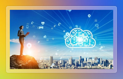 A person standing on a rock holding a tablet with a city visible in the background.