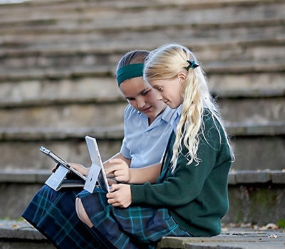 Two children looking at a tablet device together.