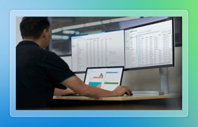 Analyst reviewing data across multiple monitors.