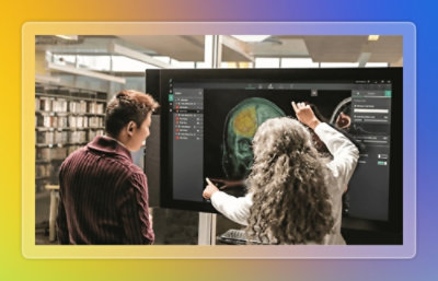 Researchers reviewing and discussing a brain scan displayed on a large interactive screen in a library or research workspace.