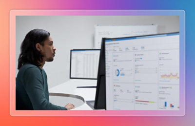 Person reviewing reports and data visualizations on a desktop monitor at a workstation.