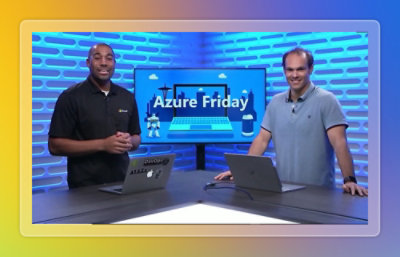 Two men standing in front of laptops with a screen displaying the text Azure Friday in the background.