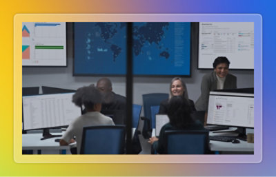 A group of people in a meeting with a person standing in front of a whiteboard.