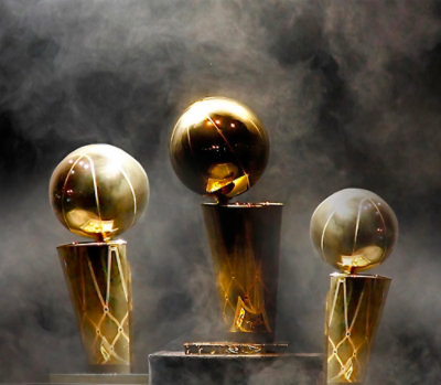 Three gold trophy statues displayed on pedestals with dramatic lighting and mist.