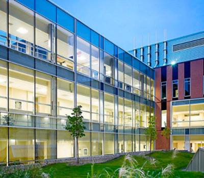 Exterior view of a contemporary office building with large glass windows and landscaped surroundings.