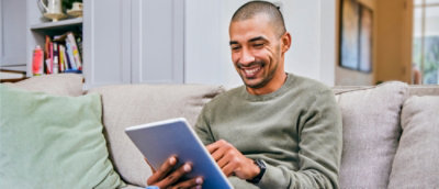 笑顔でタブレットを使っている男性。