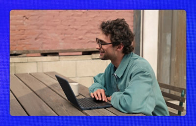 ノート PC を持っている笑顔の男性。
