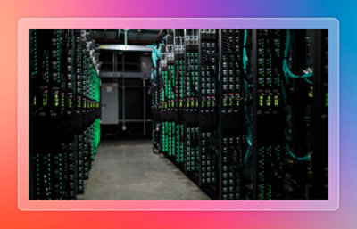 Rows of server racks with illuminated status lights inside a data center.