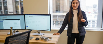 A woman sfanding beside the desktop setup