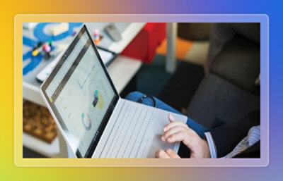 Laptop displaying data visualization charts and graphs while being used at a desk in a workspace.