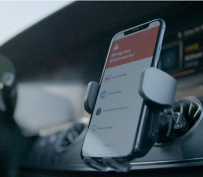 A cell phone on a holder in a car.