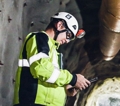 A person in a helmet and jacket watching phone