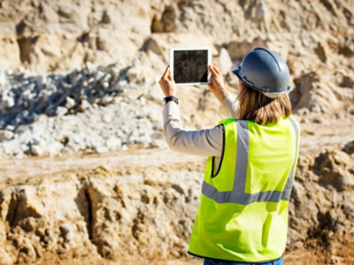 穿著安全背心並拿著平板電腦的人