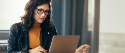 Eine Person mit Brille, die auf einen Laptop blickt.