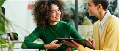 Een persoon in een groen shirt die met een andere persoon praat