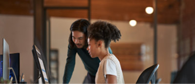 Een persoon en een andere persoon die naar het bureaublad kijkt