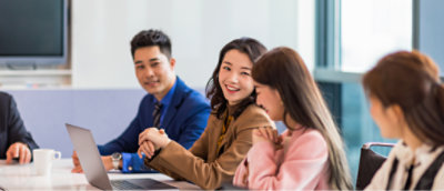 Een groep mensen die aan een tafel zit