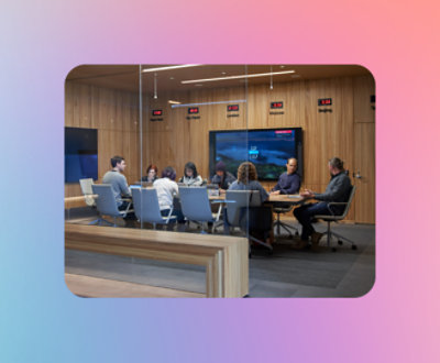 Een groep mensen die rond een tafel in een vergaderruimte zitten