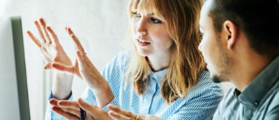 Žena s blond vlasy a modrou košilí, která tleská