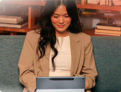  A woman sitting on a couch using a laptop.