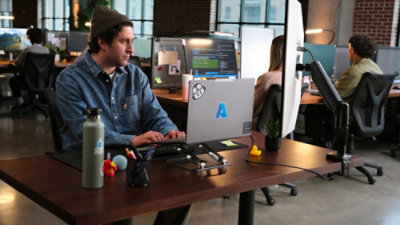 A person sitting at a desk using a laptop.
