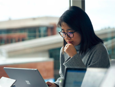  A woman sitting on a couch using a laptop.